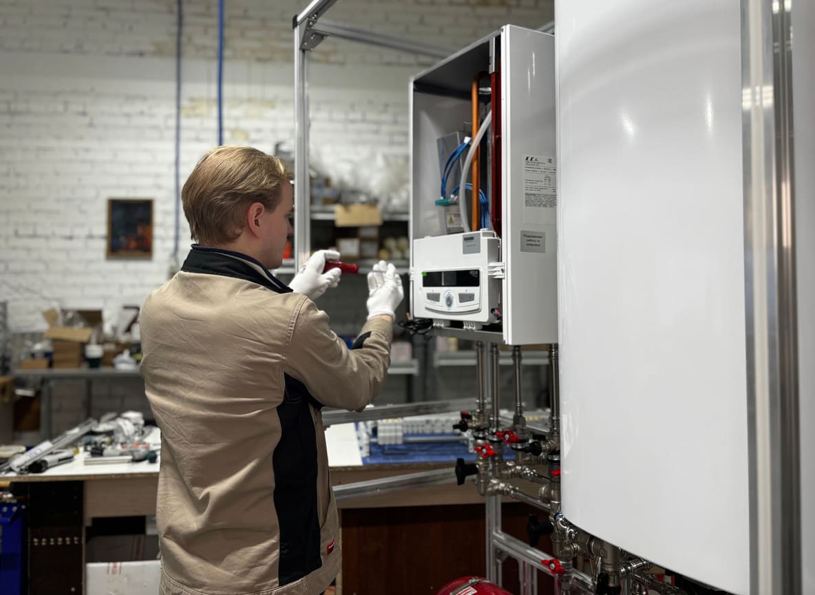Verwarmingstechnicus controleert met een looplamp de binnenzijde van een geopende wandketel