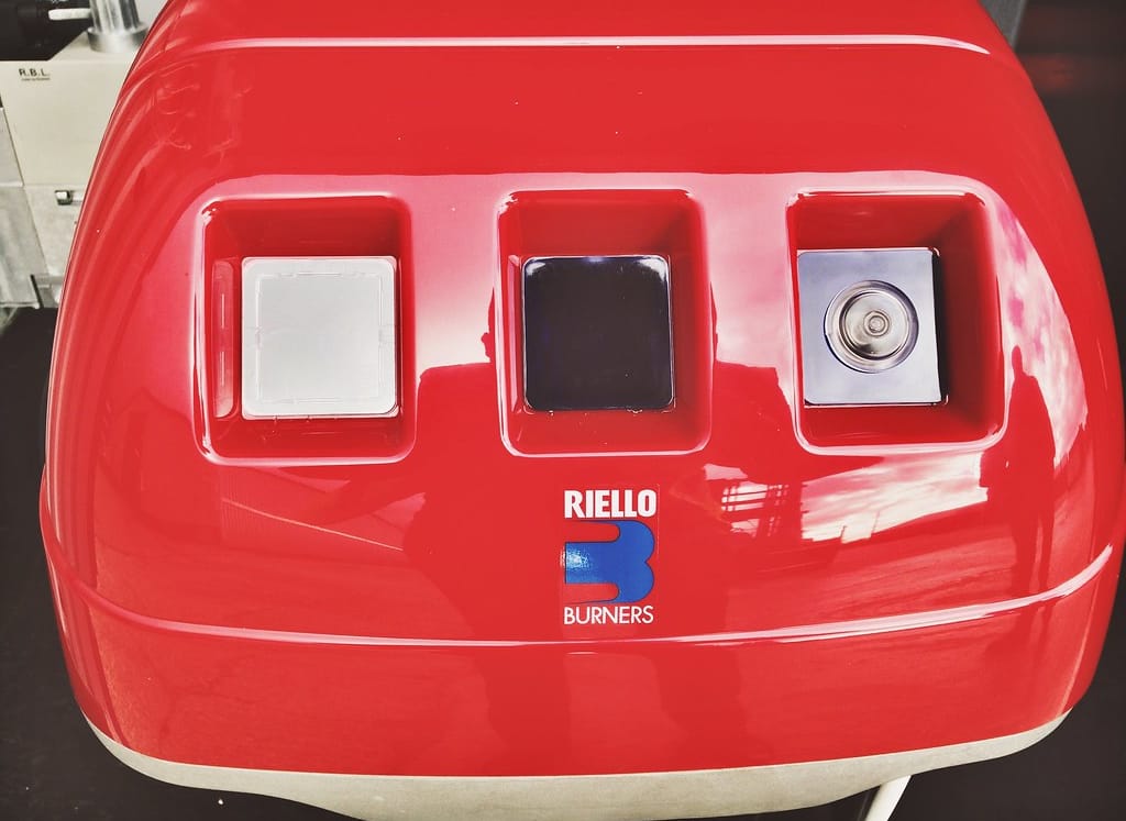 Close-up van de rode kap van een mazoutbrander gemonteerd op een verwarmingsketel