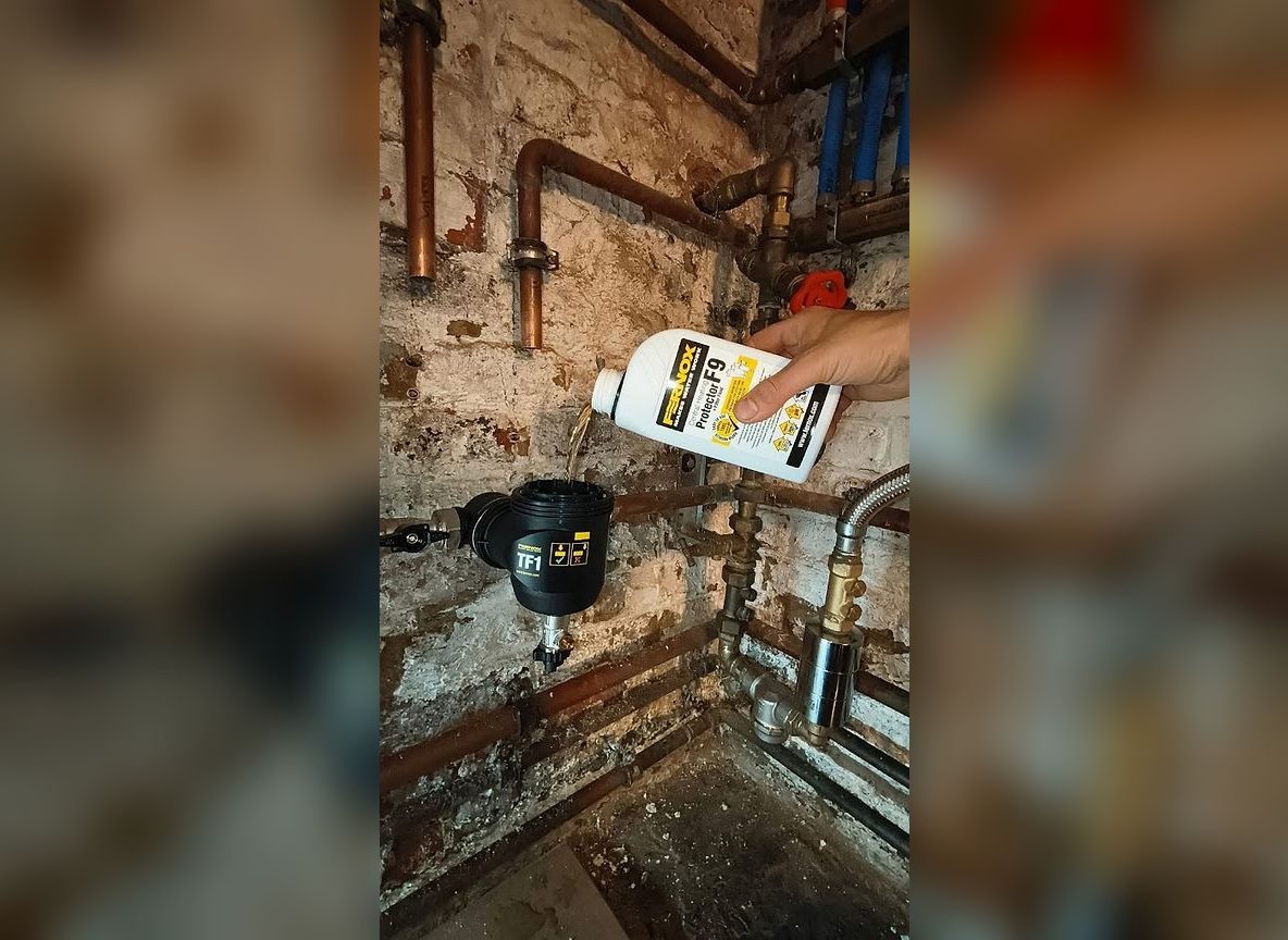 Technicus giet Fernox-beschermingsmiddel in de TF1-filter van een cv-installatie — interventie SVO Techniek